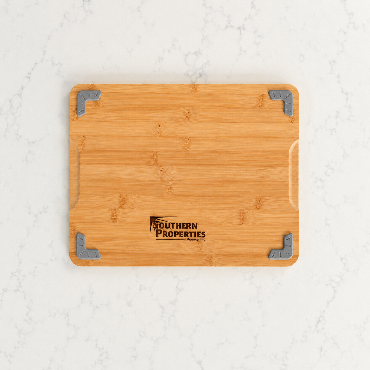 Back of bamboo cutting board engraved with a real estate company logo